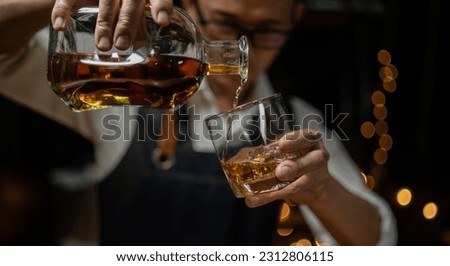 Barman pouring whiskey whiskey glass beautiful night Royalty-Free Stock Photo #2312806115