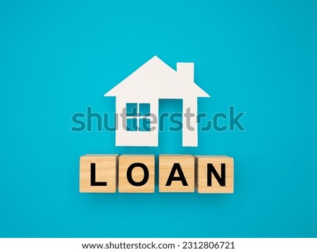 Home loan and risk management concept. Property investment and house mortgage. House made of paper and wooden cubes with the letters LOAN is on a blue background.