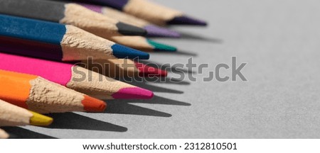 Set of colored pencils on grey table.