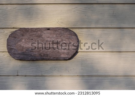 A blank wooden sign hung on the wall.