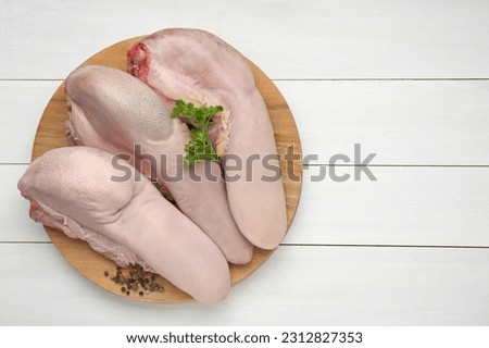 Raw beef tongues, peppercorns and parsley on white wooden table, top view. Space for text Royalty-Free Stock Photo #2312827353