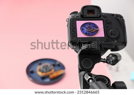 Professional camera with picture of delicious dessert on display in photo studio, space for text. Food photography