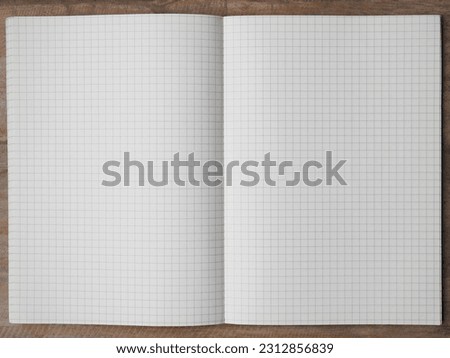 2pages of grid notebook on wooden table close up