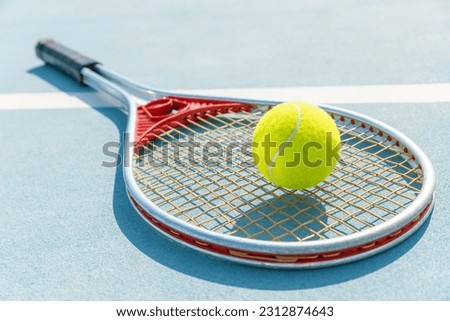 Vintage tennis racket with a ball on the tennis court.  Royalty-Free Stock Photo #2312874643
