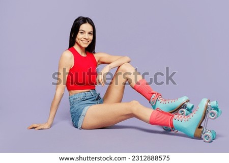 Full body side profile view young latin woman she wear red casual clothes rollers rollerblading looking camera posing isolated on plain pastel purple background. Summer sport lifestyle leisure concept