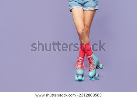 Close up cropped female legs in rollerblades rollers shorts isolated on pastel plain light purple violet wall background studio. Summer sport lifestyle leisure concept. Copy space advertising mock up