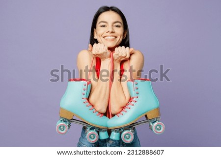 Young cheerful smiling happy latin woman she wear red casual clothes hold in hand rollers look camera isolated on plain pastel purple background studio portrait. Summer sport lifestyle leisure concept