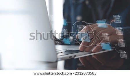Document Management System (DMS) being setup by IT consultant working on laptop computer in office. Software for archiving, searching and managing corporate files and information Royalty-Free Stock Photo #2312893585