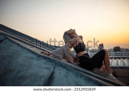 Photo shoot on the roof. Young woman posing in the roof at sunset.  People, lifestyle, relaxation concept.