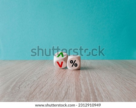 Interest rates symbol. Wooden cubes with the direction of an arrow symbolizing that the interest rates are going down or up. Beautiful wooden table, white background. Business concept. Copy space.