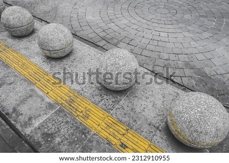 Yellow Tactile Paving for disabled, Concrete round bollard ball barrier to protect pedestrians and roadside decoration. Town square, urban, city, infrastructure. Braille tenji blocks, infrastructure.