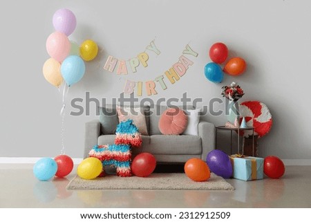 Interior of living room decorated for birthday with balloons, pinatas and garland Royalty-Free Stock Photo #2312912509