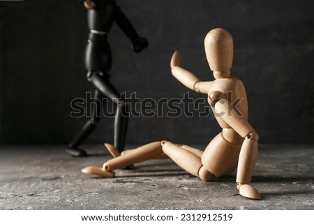 Wooden mannequins on table against dark background. Domestic violence concept Royalty-Free Stock Photo #2312912519