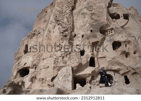 A girl in hijab posing for a photo with natural carved rock mountain as background.Cappadocia is famous for its nature beauty and unique landscape