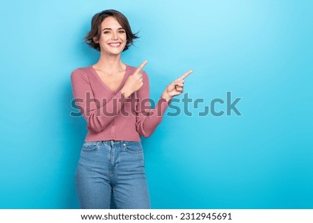 Photo of pretty shiny woman dressed pink shirt pointing two fingers empty space isolated blue color background