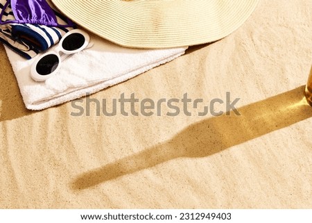 Shadow of beer bottle on warm sand. Textured. Beach chili on warm summer day with cool drink, refreshment and relaxation. Concept of alcohol drink, taste, summer vacation, holiday, brewery. Ad