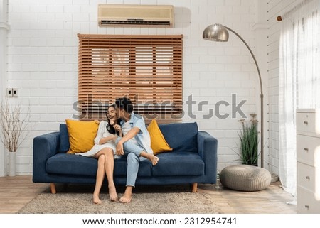 Asian young man surprise and give rose flower to beautiful girlfriend. Attractive romantic new marriage couple male and woman spend time to celebrate anniversary and valentine's day together in house.