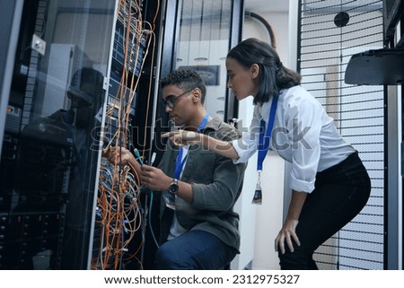 IT people, engineer or server room cable for programming or connection maintenance. Man and woman technician in datacenter for network, cybersecurity software or data center problem or system upgrade Royalty-Free Stock Photo #2312975327