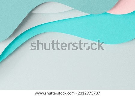 Abstract colored paper texture background. Paper cut composition with layers of geometric shapes and lines in turquoise, aquamarine, pastel green and pink colors. Top view