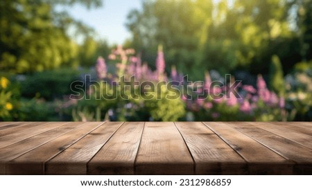 The empty wooden table top with blur background of English garden. Exuberant image.