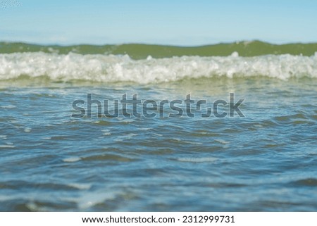 Close-up of the sea surface in soft focus. Warm waves of the ocean. Background on the theme of a pleasant romantic holiday. Beach vacation from work.
