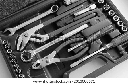 Black case with separated slots in shape of variety repairing hand tools angle view monochrome stock photo Royalty-Free Stock Photo #2313008591