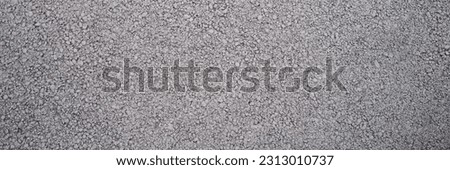 Rough texture of wall made of small gray cement pebbles