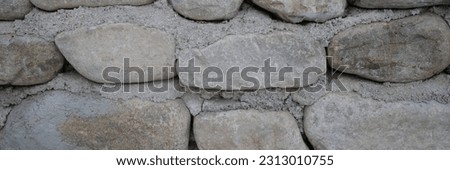 Neatly stacked rough cut stone wall seamless texture background