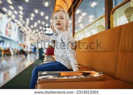 Adorable preschooler girl having fun in international airport. Travel with kids concept