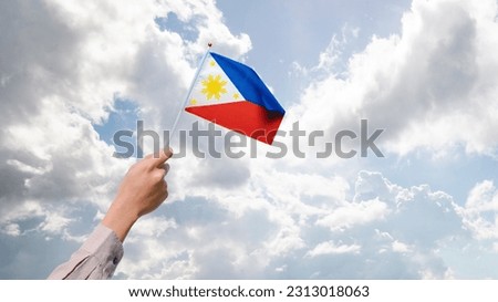 A human hand holding a Philippine flag. Philippines Independence Day concept