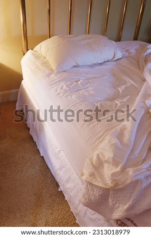 a lonely unmade brass bed. Royalty-Free Stock Photo #2313018979
