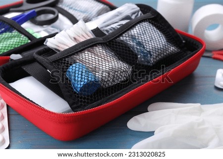 First aid kit on blue wooden table, closeup Royalty-Free Stock Photo #2313020825