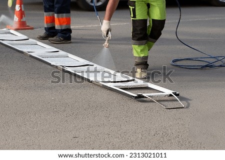 Installation of markings on the road. Repair of the road for cars in the city. Royalty-Free Stock Photo #2313021011