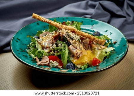 Salad with duck, tomatoes and mango sauce in a plate