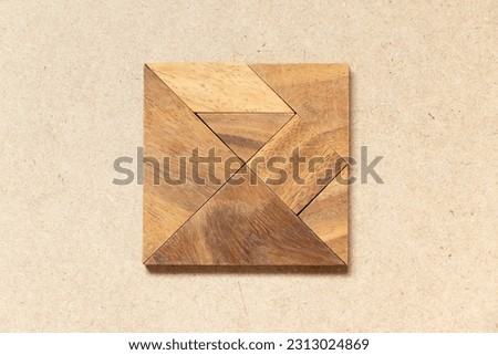 Wooden tangram in square or rectangle shape on wood background