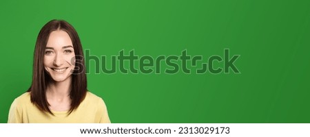 Chroma key compositing. Beautiful young woman smiling against green screen