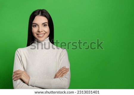 Chroma key compositing. Happy young woman with dark hair against green screen