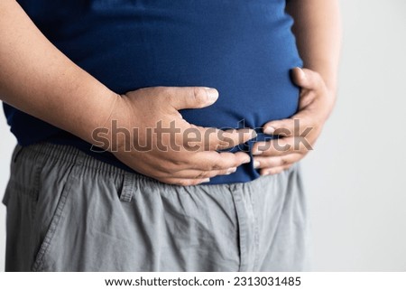 fat middle aged old asian man belly, concept of overweight, dad bod, over eating, obesity, unhealthy lifestyle Royalty-Free Stock Photo #2313031485
