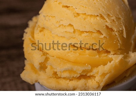 Yellow ice cream close-up photograph of frozen desserts. Food aligned to the right of the image.