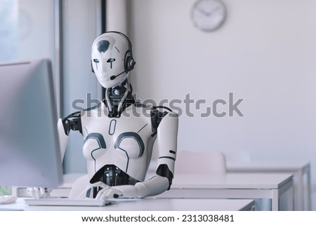 Android AI robot sitting at the desk and working in the office: artificial intelligence, business and automation concept Royalty-Free Stock Photo #2313038481