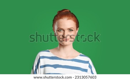 Chroma key compositing. Beautiful young woman with red hair against green screen