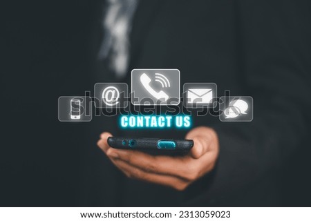 Contact us or Customer support hotline people connect, Person hand using smart phone with Contact us icon on VR screen on office desk, email, address, live chat, internet wifi.