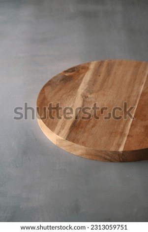 photo round wooden cutting board on a light gray background