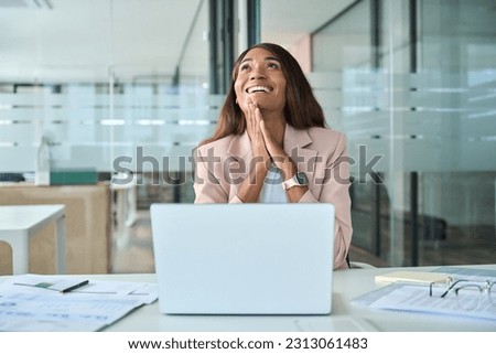 Motivated professional young African American business woman executive feeling happy about financial work results, job promotion or corporate goals achievement sitting with laptop in office. Royalty-Free Stock Photo #2313061483