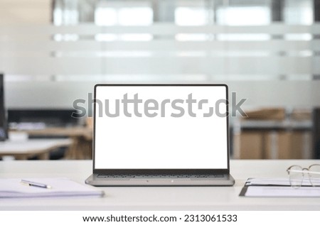 Laptop device mock up template design on office workplace desk, white mockup empty blank computer screen on office work table business web technology at modern workspace, closeup.