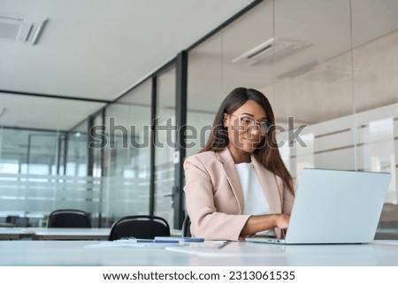 Busy professional business woman employee working looking at computer typing in office. Young African American female company finance manager executive using laptop sitting at desk. Copy space Royalty-Free Stock Photo #2313061535