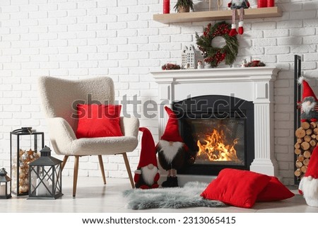 Beautiful Christmas themed photo zone with armchair and fireplace in room