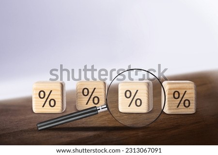 Wooden cube and percent sign on the desk