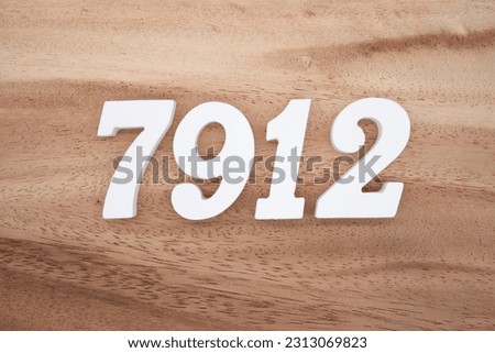 White number 7912 on a brown and light brown wooden background.