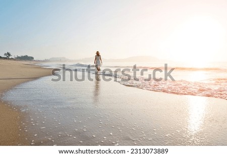 Young woman walking at the beach. Royalty-Free Stock Photo #2313073889